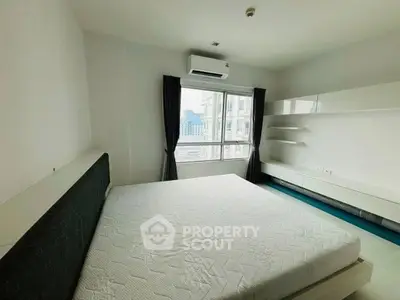 Spacious bedroom with city view, modern furnishings, and ample natural light.