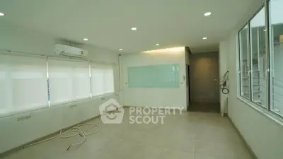 Spacious unfurnished room with large windows and air conditioning, perfect for customization.