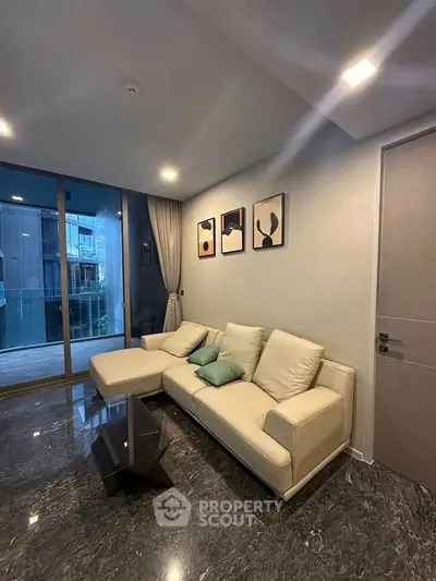 Modern living room with elegant marble flooring and stylish decor, featuring a cozy sofa and artistic wall art.