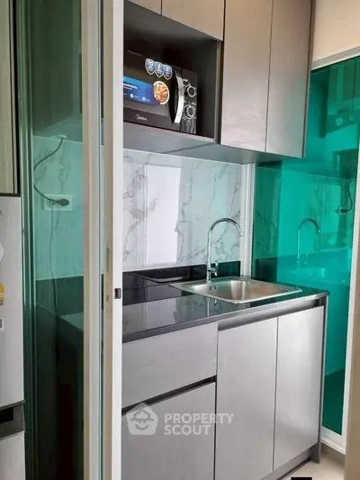 Modern compact kitchen with sleek cabinetry and stainless steel sink