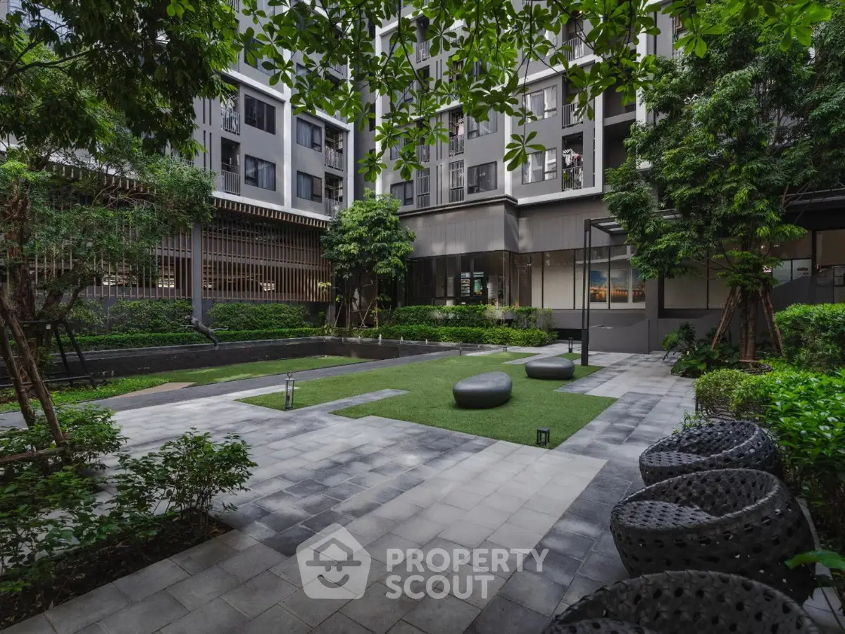 Modern apartment building with lush garden and seating area, perfect for relaxation and outdoor activities.