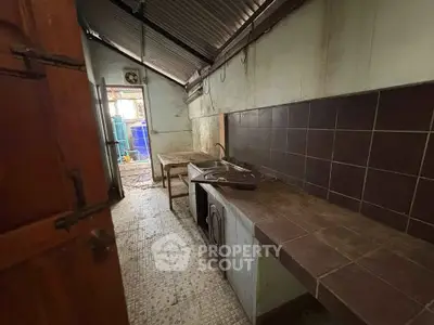 Rustic kitchen with tiled countertops and open layout, ideal for renovation projects.