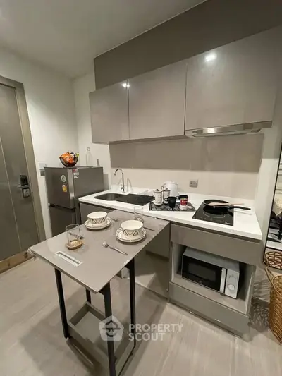 Modern compact kitchen with sleek cabinetry and integrated appliances in a stylish apartment.