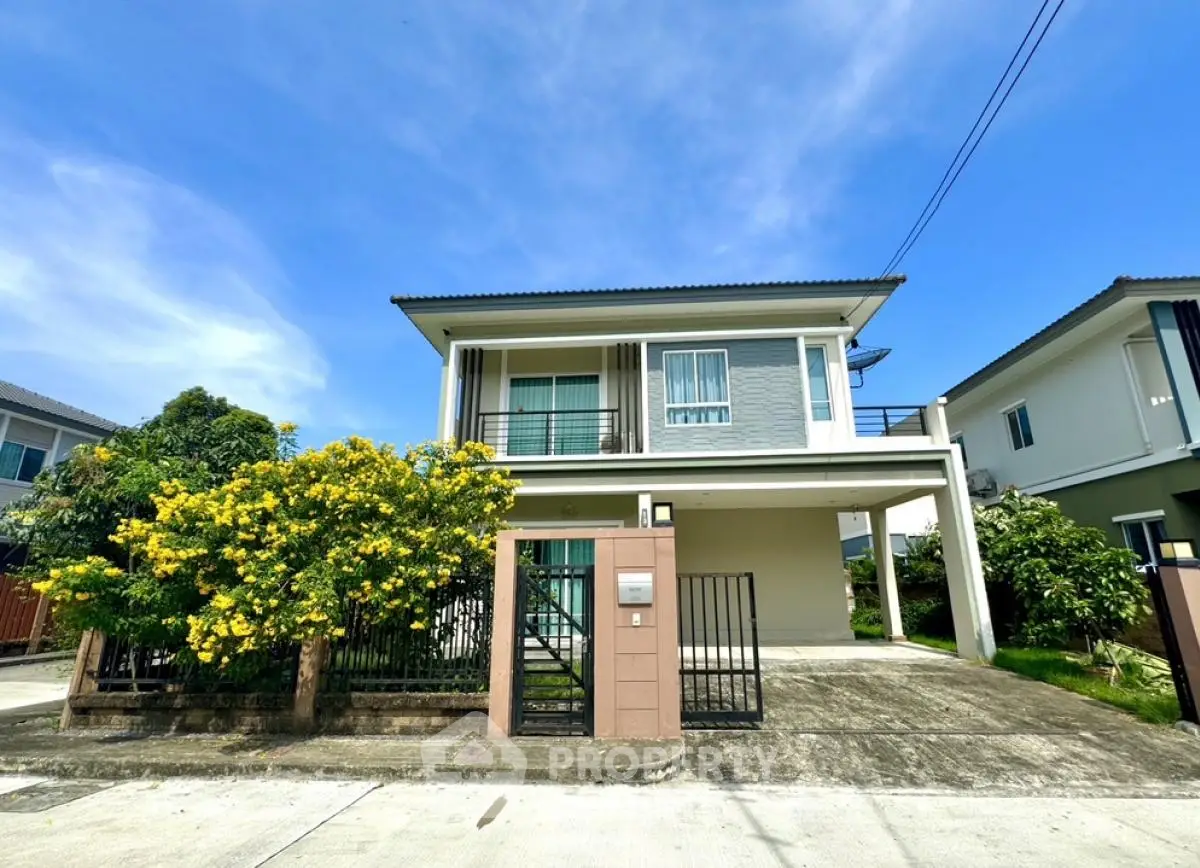 Modern two-story house with lush garden and spacious driveway in a serene neighborhood.