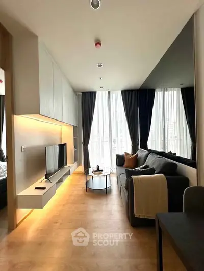 Modern living room with sleek design, large windows, and stylish furniture in a high-rise apartment.