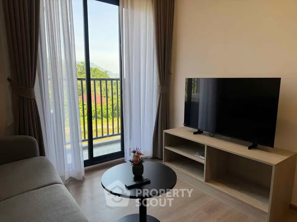 Modern living room with large window and TV, offering a bright and inviting atmosphere.
