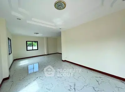 Spacious empty room with elegant marble flooring and ample natural light