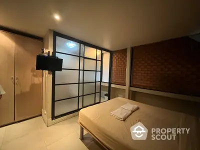 Cozy bedroom with modern design, featuring a large bed, sleek sliding glass doors, and ambient lighting, ideal for relaxation and comfort.