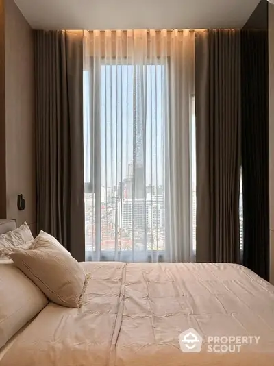 Luxurious bedroom with stunning city view through floor-to-ceiling windows and elegant curtains.