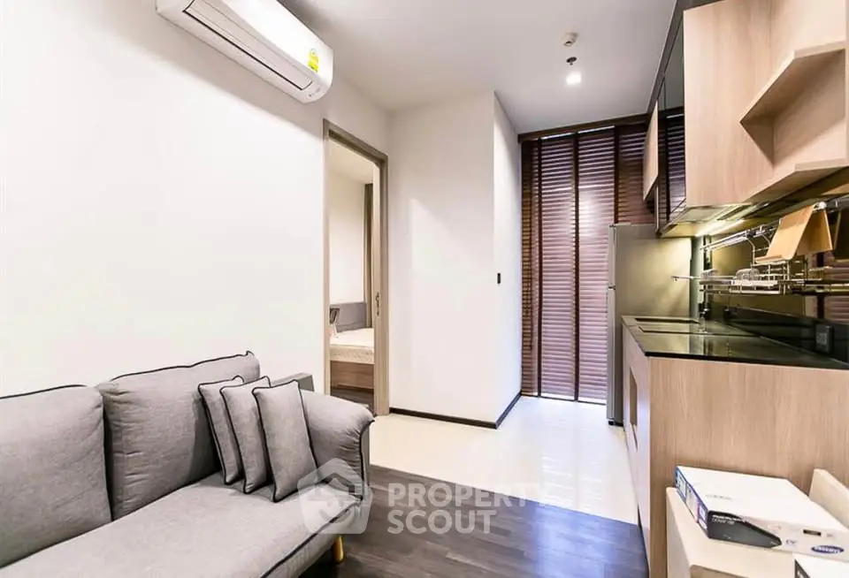 Modern apartment interior with sleek kitchen and cozy living area, featuring stylish decor and efficient layout.