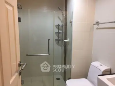 Modern bathroom with glass shower enclosure and sleek fixtures.