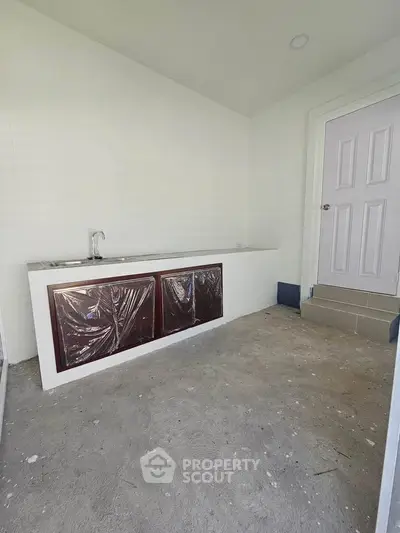 Minimalist kitchen area with closed layout and basic fixtures