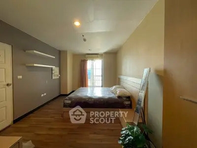 Spacious bedroom with modern decor and natural light in a stylish apartment.