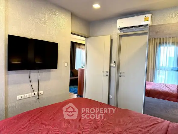 Modern bedroom with wall-mounted TV and air conditioning unit