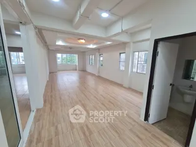 Spacious open-plan living area with tiled flooring and ample natural light