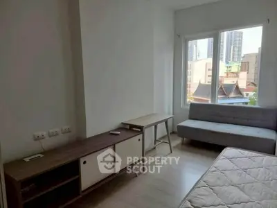 Bright bedroom with modern furniture and city view, perfect for urban living.