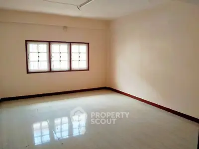 Spacious empty room with large windows and natural light, perfect for customization.