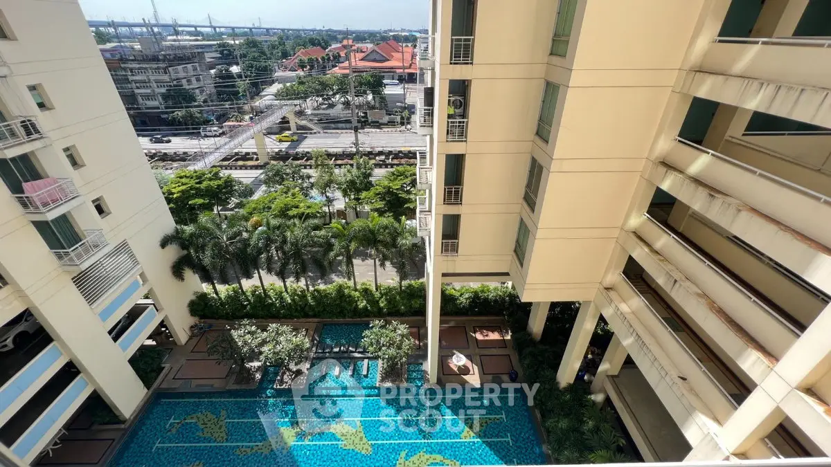 Stunning aerial view of modern apartment complex with pool and lush greenery, perfect for urban living.