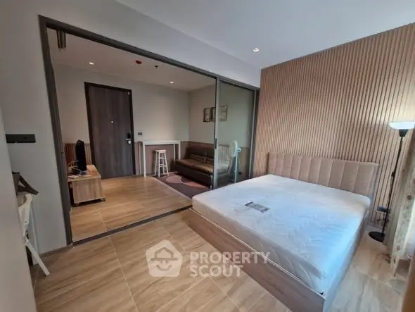 Modern studio apartment with wooden flooring and glass partition