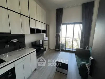 Modern living room with sleek kitchen and balcony view in a stylish apartment.