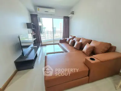 Modern living room with brown leather sectional sofa and city view balcony.