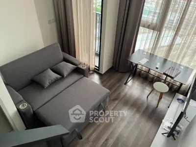 Modern living room with stylish gray sofa and sleek wooden flooring