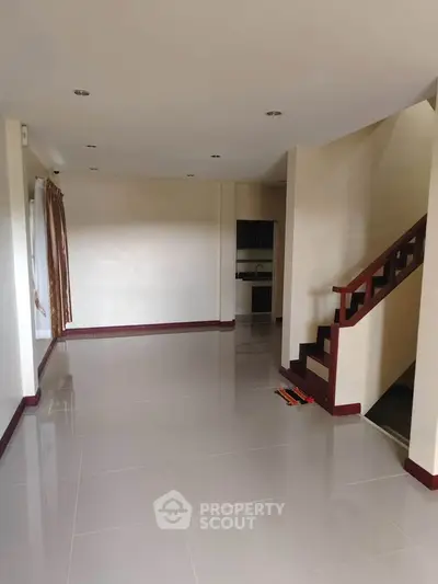 Spacious empty living room with staircase and tiled flooring in modern home