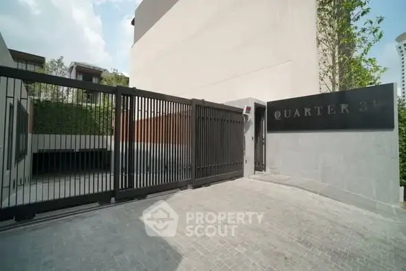 Modern gated entrance of luxury residential building with sleek design and secure access.