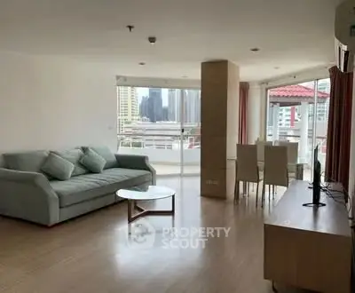 Spacious living room with modern furniture and city view, perfect for urban living.