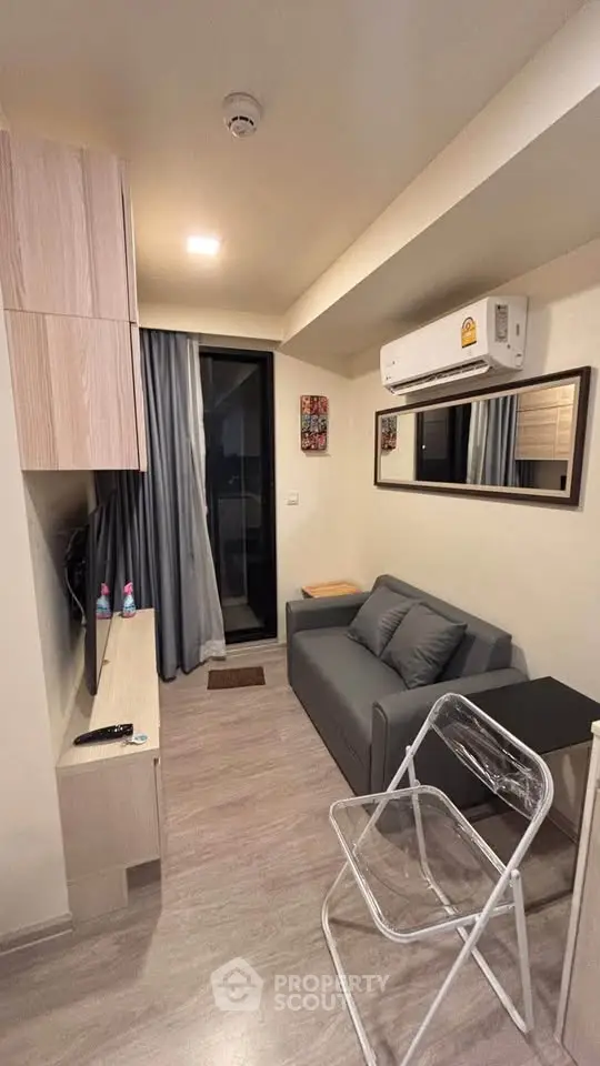 Cozy living room with modern decor and air conditioning in a compact apartment.