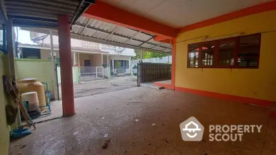 Spacious covered outdoor area with tiled flooring and open view to residential street.