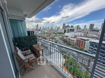 Stunning city view from a modern balcony with cozy seating area, perfect for relaxation and enjoying the skyline.