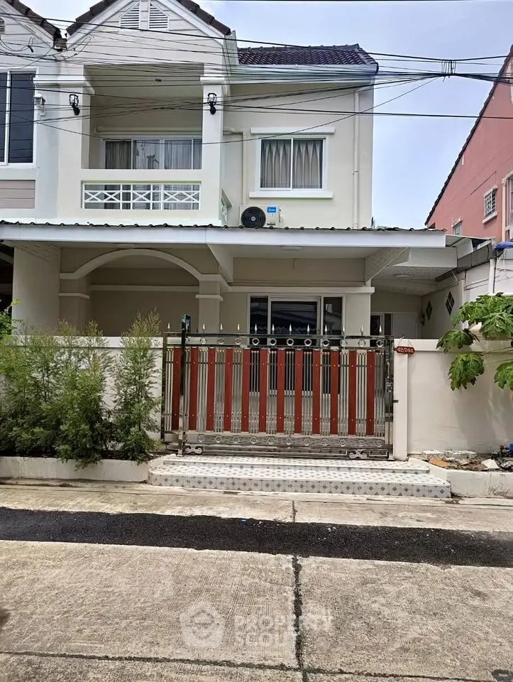 Charming two-story house with gated entrance and balcony in a serene neighborhood.