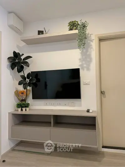 Modern living room with wall-mounted TV and stylish shelving