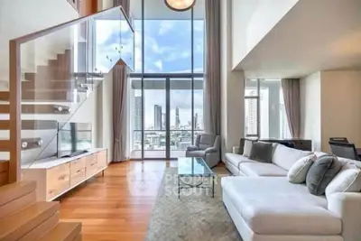 Luxurious high-rise living room with stunning city view and modern staircase