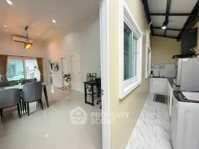 Modern open-plan living and dining area with adjacent kitchen in a stylish home.