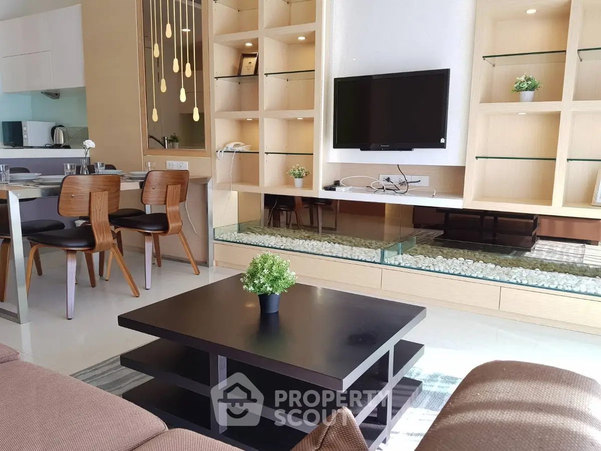 Modern living room with stylish shelving, wall-mounted TV, and elegant dining area.