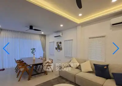 Spacious modern living room with elegant dining area and cozy seating, featuring stylish lighting and air conditioning.