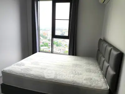 Modern bedroom with large window offering stunning city views and stylish bed frame.