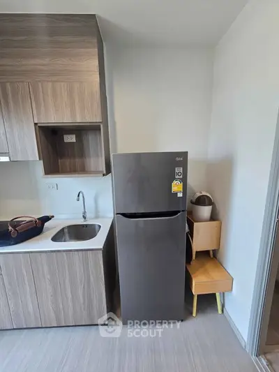 Modern kitchen with sleek fridge and stylish cabinetry in compact layout