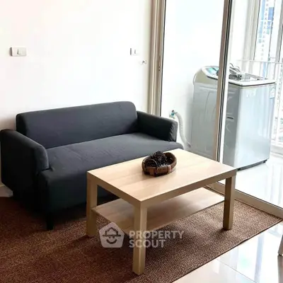Modern living room with compact sofa and washing machine in bright apartment