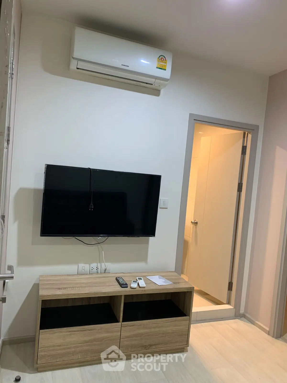Modern living room with wall-mounted TV and air conditioning unit