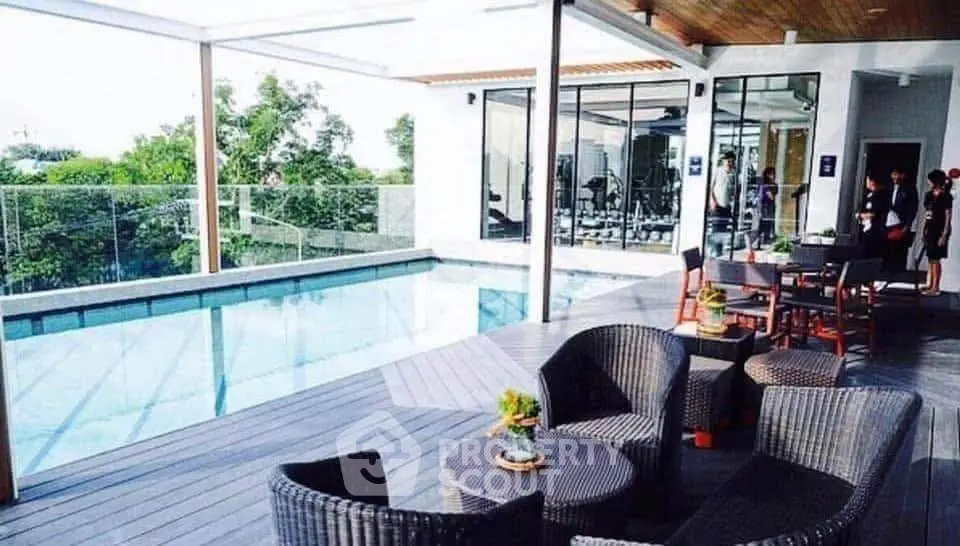 Luxurious rooftop pool area with modern seating and glass railing, perfect for relaxation and entertainment.