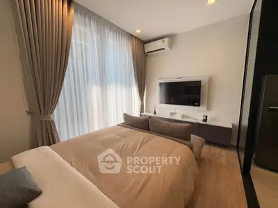 Luxurious bedroom with modern decor, featuring a wall-mounted TV and elegant curtains, perfect for relaxation.