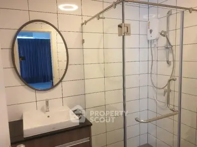 Modern bathroom with glass shower and stylish vanity in a contemporary apartment.