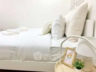 Cozy and inviting bedroom with plush white bedding and stylish decor, perfect for relaxation and comfort.