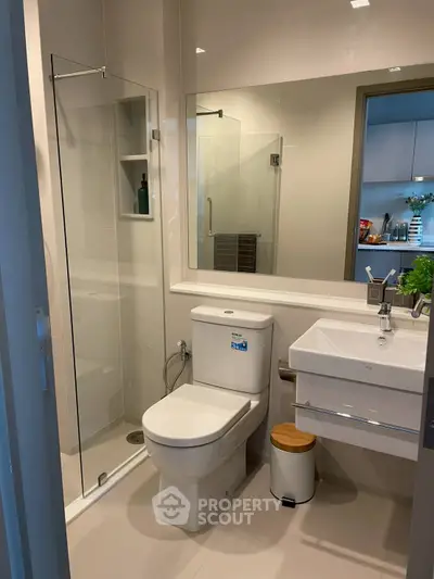Modern bathroom with glass shower, sleek fixtures, and neutral tones for a contemporary feel.