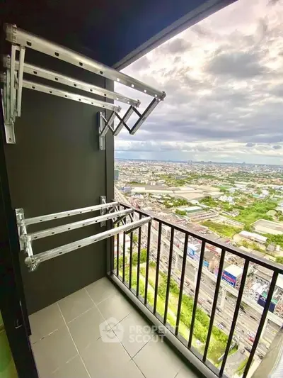 High-rise balcony with stunning cityscape view and modern drying racks.