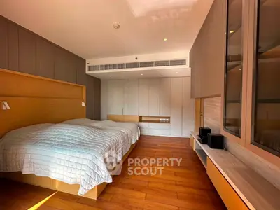 Spacious modern bedroom with twin beds and elegant wooden flooring