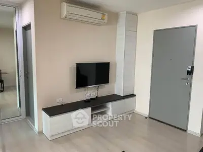 Modern living room with sleek TV unit and air conditioning in a stylish apartment.